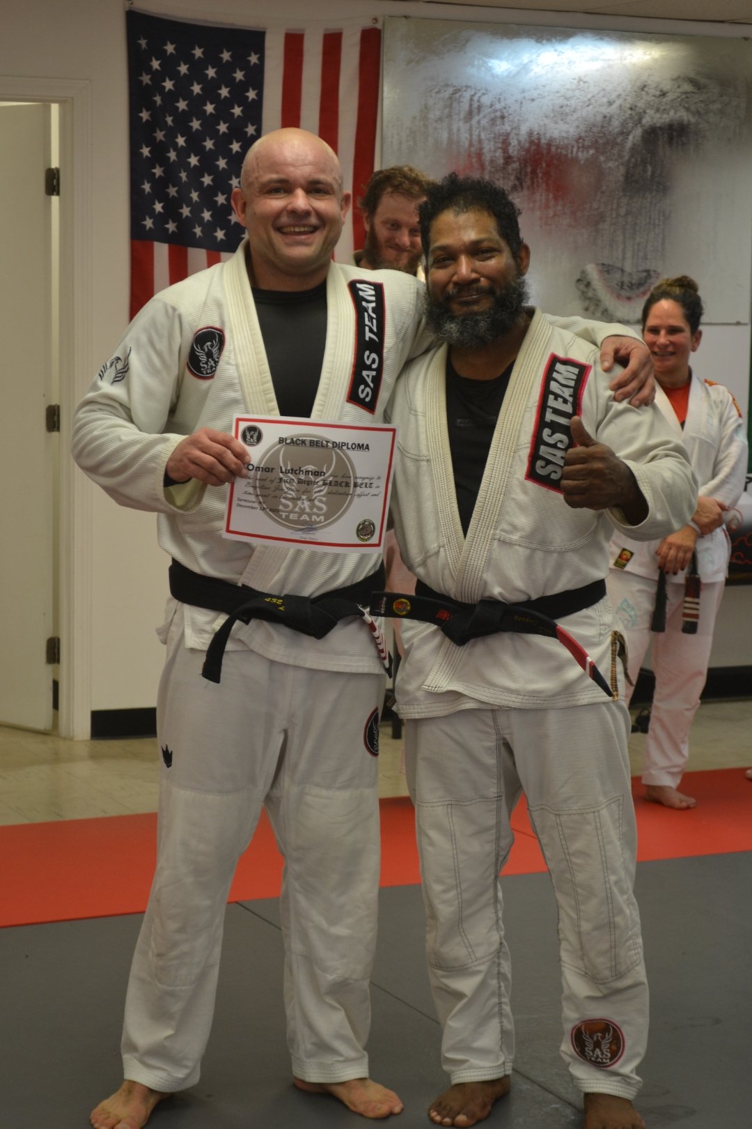 Coach O receiving BJJ Black Belt diploma