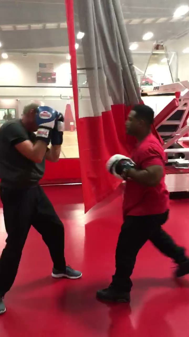 Coach O holding focus mitts during a boxing training session